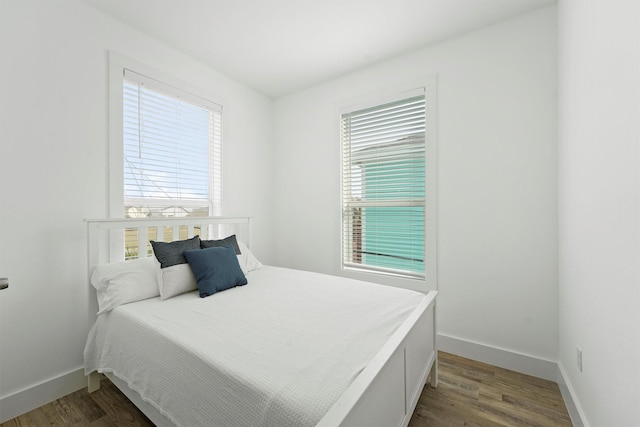 bedroom with dark hardwood / wood-style floors