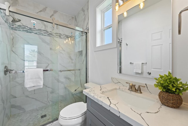 bathroom featuring vanity, toilet, and a shower with door