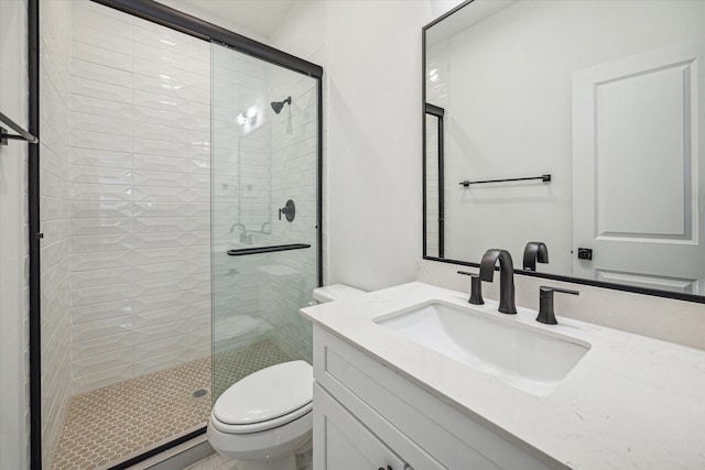 bathroom featuring vanity, toilet, and a shower with shower door