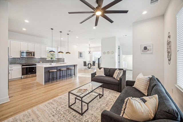 living room with ceiling fan and light wood-type flooring