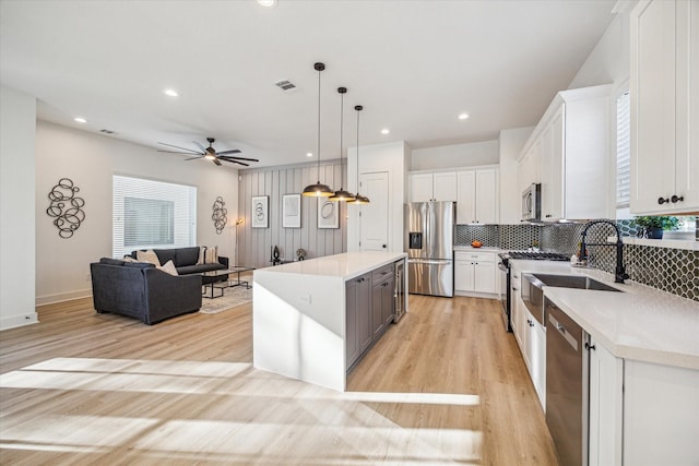 kitchen featuring white cabinetry, pendant lighting, stainless steel appliances, and a kitchen island