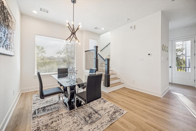 dining space featuring an inviting chandelier and light hardwood / wood-style floors