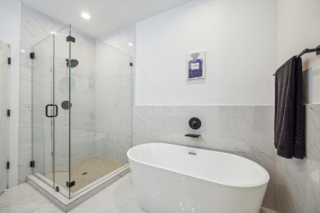 bathroom featuring separate shower and tub and tile walls