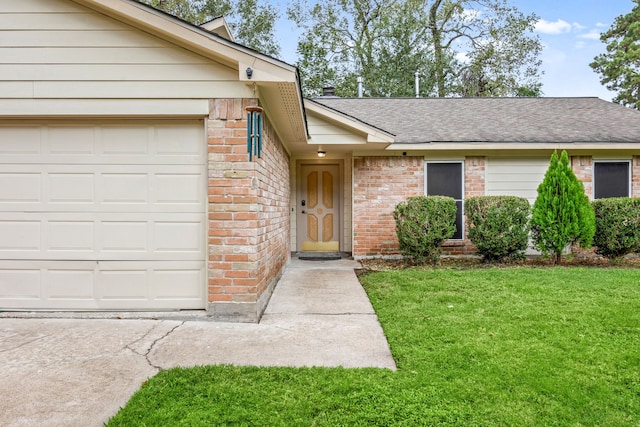 view of exterior entry with a garage and a lawn