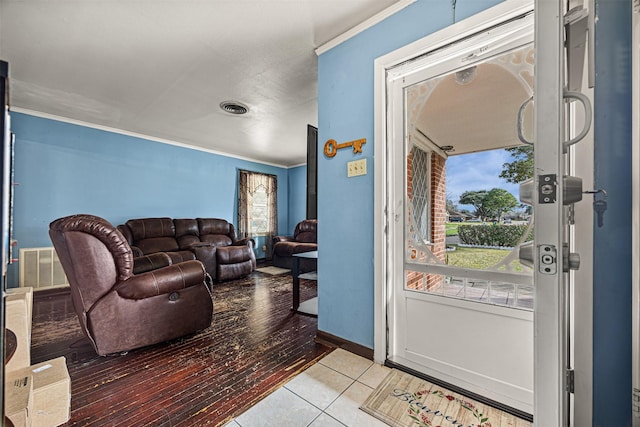 entrance foyer with crown molding and light tile patterned floors