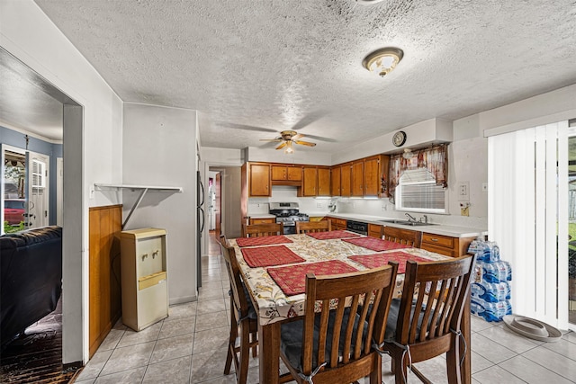 dining space featuring sink, light tile patterned floors, a textured ceiling, and ceiling fan