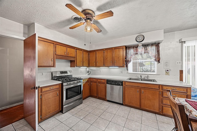 kitchen featuring sink, ceiling fan, appliances with stainless steel finishes, a textured ceiling, and light tile patterned flooring