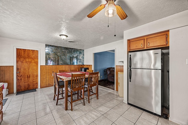 dining room with wooden walls, washer / clothes dryer, and a textured ceiling