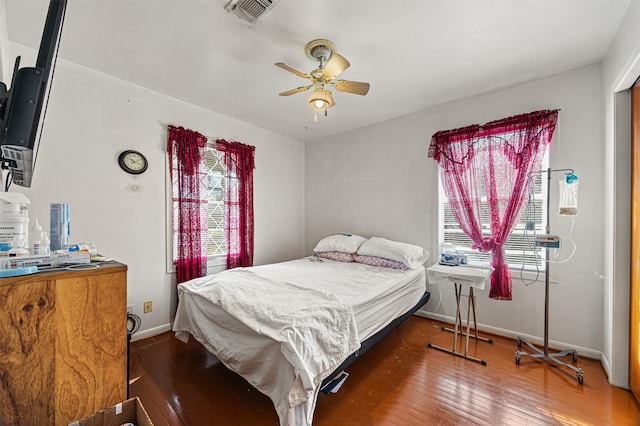 bedroom with dark hardwood / wood-style floors and ceiling fan