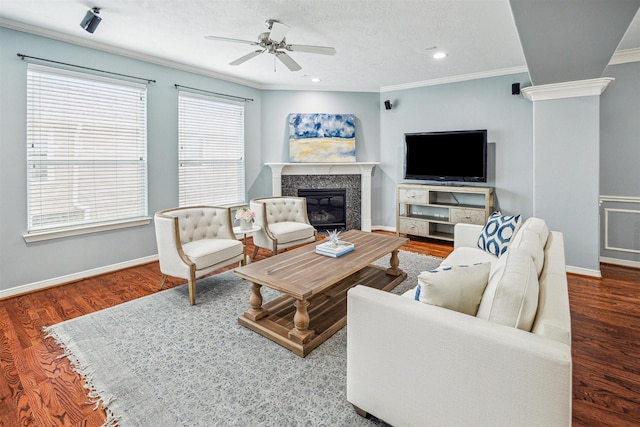 living room with crown molding, a high end fireplace, wood-type flooring, and ceiling fan