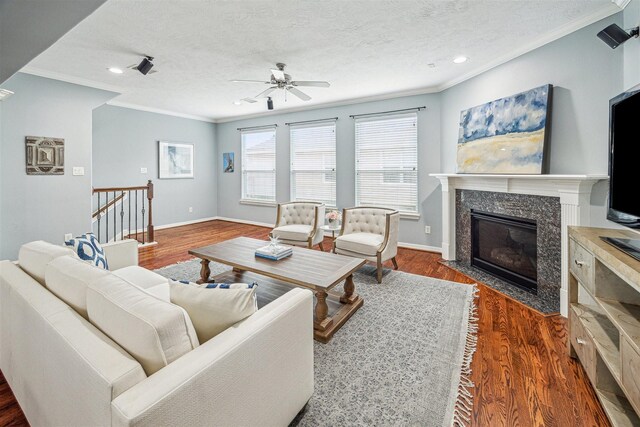 living room with ornamental molding, dark hardwood / wood-style floors, a high end fireplace, and a textured ceiling