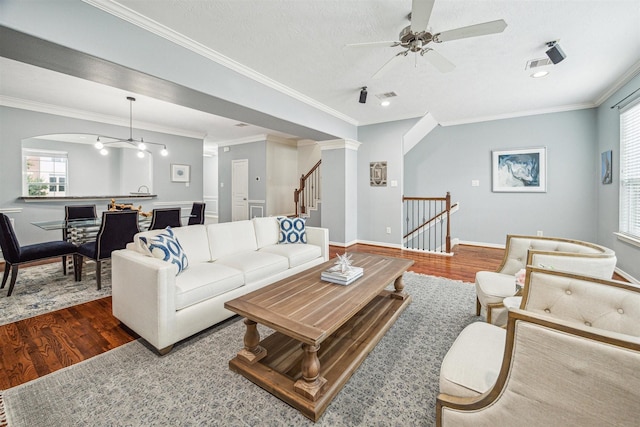 living room featuring ceiling fan, ornamental molding, dark hardwood / wood-style floors, and a textured ceiling