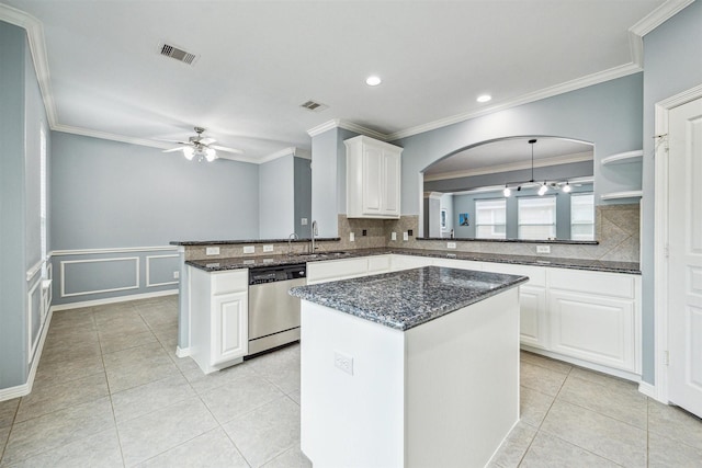 kitchen with stainless steel dishwasher, kitchen peninsula, white cabinets, and a kitchen island