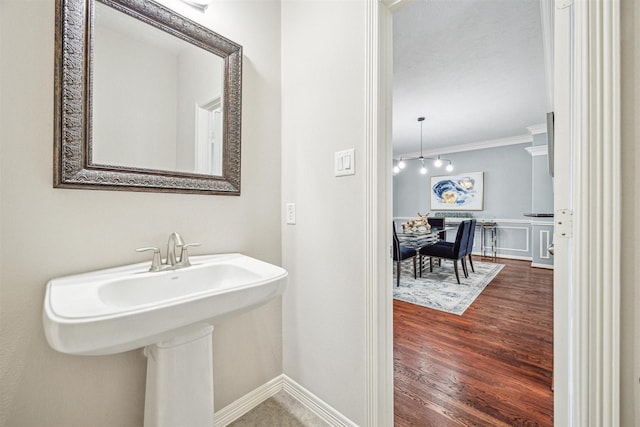 bathroom with ornamental molding and hardwood / wood-style floors