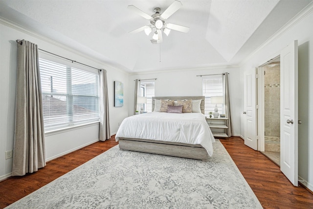 bedroom featuring ceiling fan, dark hardwood / wood-style floors, ensuite bathroom, a tray ceiling, and ornamental molding