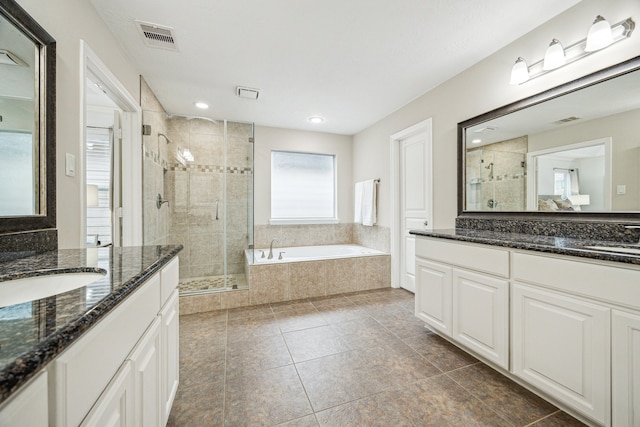 bathroom featuring vanity, tile patterned flooring, and plus walk in shower