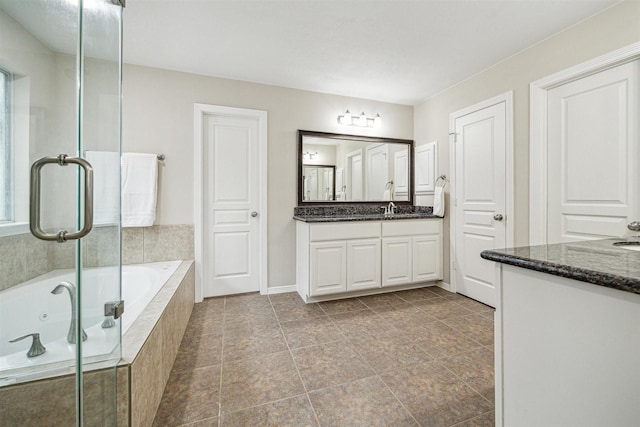 bathroom featuring vanity and tiled bath