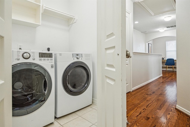 laundry room with independent washer and dryer and light wood-type flooring