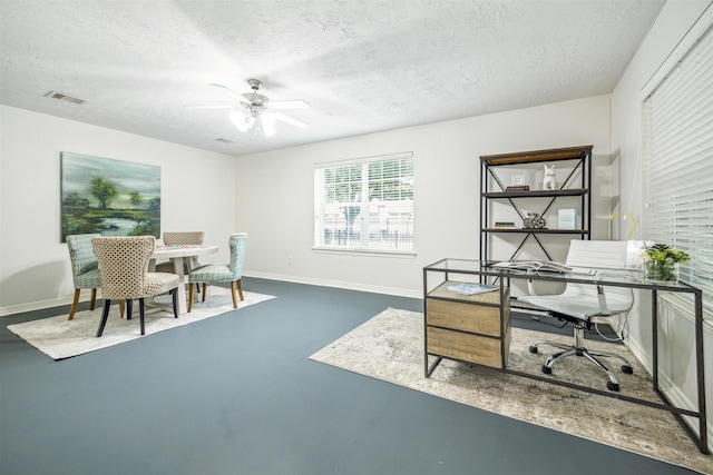 home office featuring ceiling fan and a textured ceiling