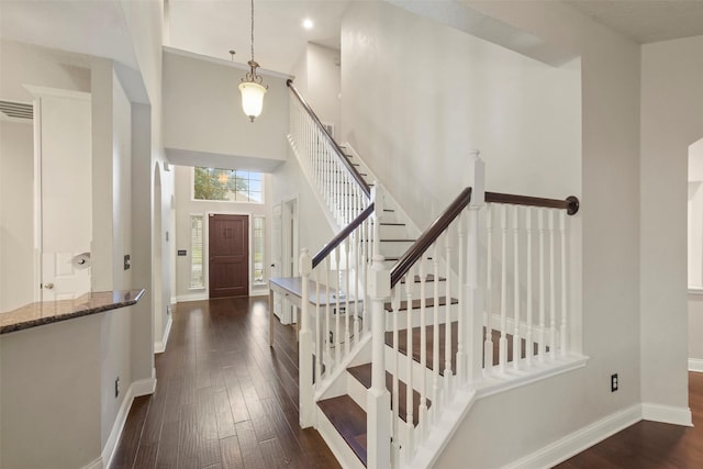 entryway featuring a towering ceiling and dark hardwood / wood-style floors