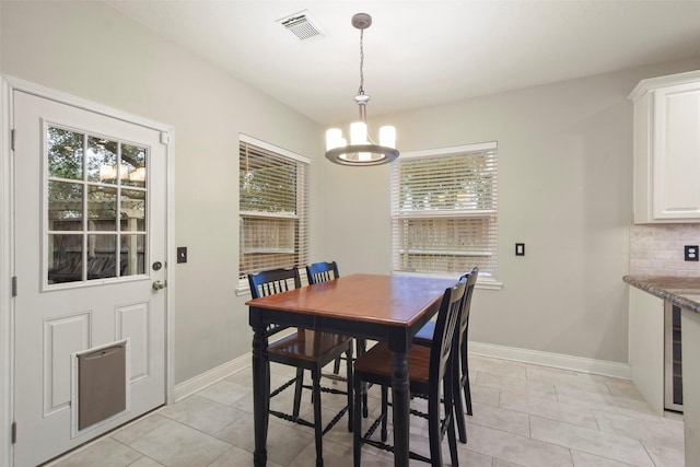 tiled dining area with an inviting chandelier