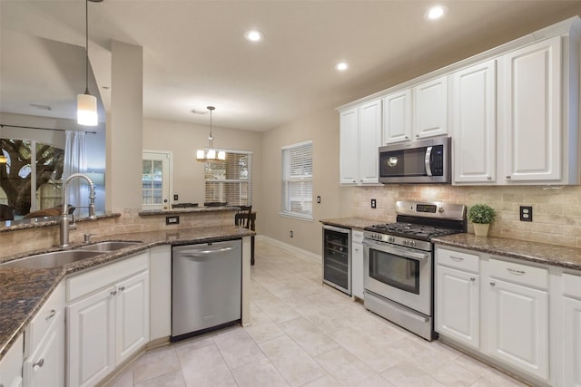 kitchen with stainless steel appliances, decorative light fixtures, sink, and white cabinets