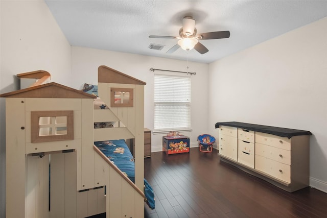 bedroom featuring ceiling fan, dark wood-type flooring, and a textured ceiling