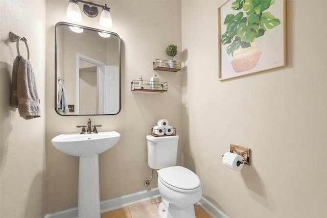 bathroom with toilet and tile patterned flooring