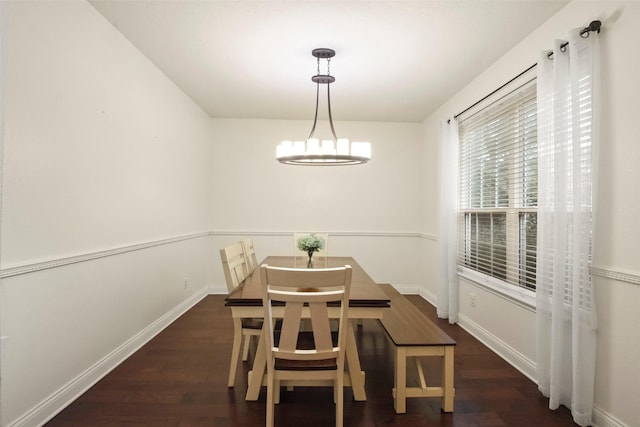 dining room with dark hardwood / wood-style flooring and a chandelier