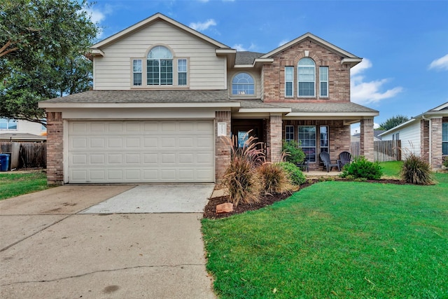 view of front of property with a garage, covered porch, and a front yard