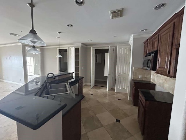 kitchen with appliances with stainless steel finishes, pendant lighting, tasteful backsplash, sink, and crown molding