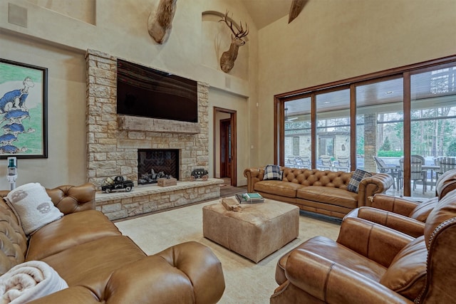 living room with beamed ceiling, a stone fireplace, and high vaulted ceiling