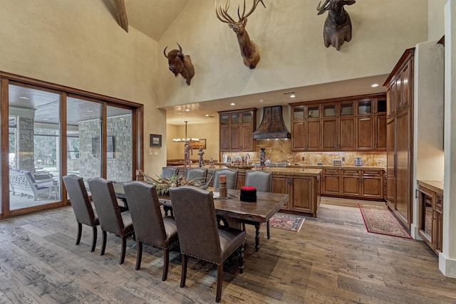 dining space with wood-type flooring and high vaulted ceiling