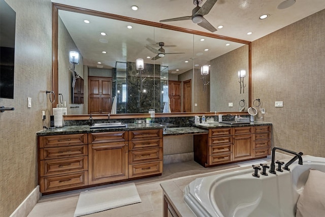 bathroom with a relaxing tiled tub, vanity, and ceiling fan