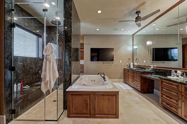 bathroom with ceiling fan, vanity, and plus walk in shower