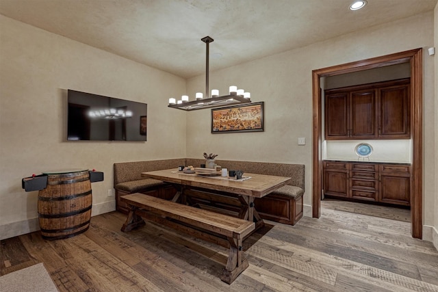 dining area featuring breakfast area, an inviting chandelier, and light wood-type flooring