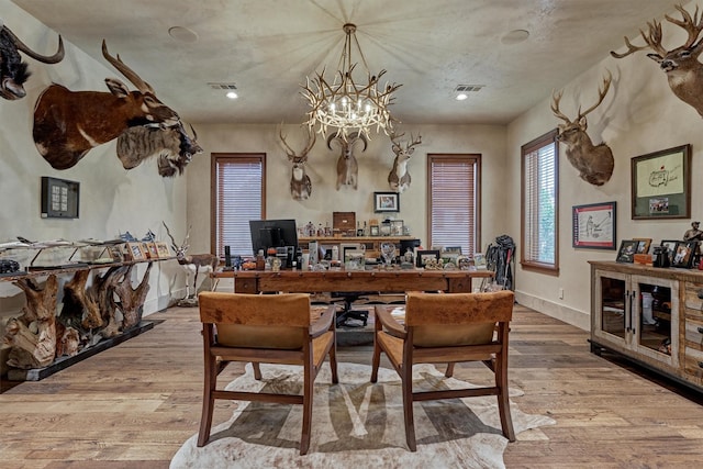 dining space featuring hardwood / wood-style flooring and a notable chandelier