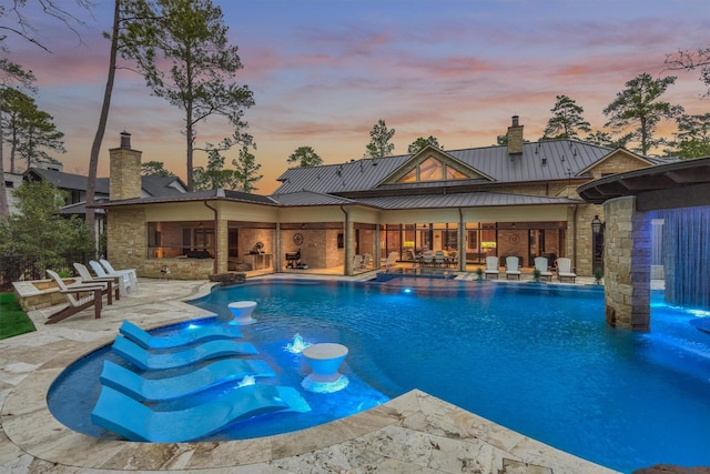 pool at dusk featuring a patio area