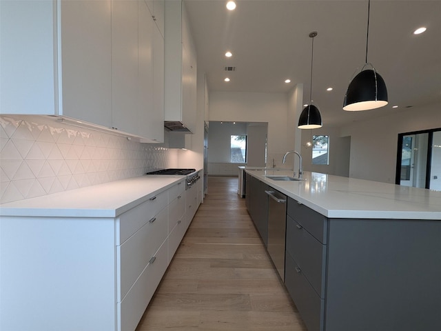 kitchen with white cabinetry, sink, and decorative light fixtures