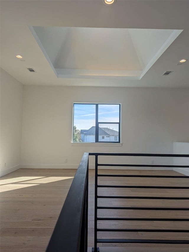 interior space featuring hardwood / wood-style flooring and a raised ceiling