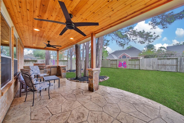 view of patio with exterior kitchen, area for grilling, and ceiling fan