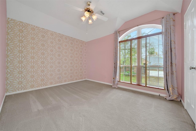 carpeted empty room with vaulted ceiling and ceiling fan