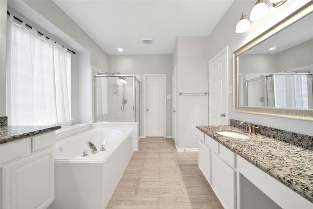 bathroom with vanity and separate shower and tub