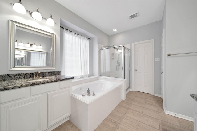 bathroom featuring independent shower and bath and vanity