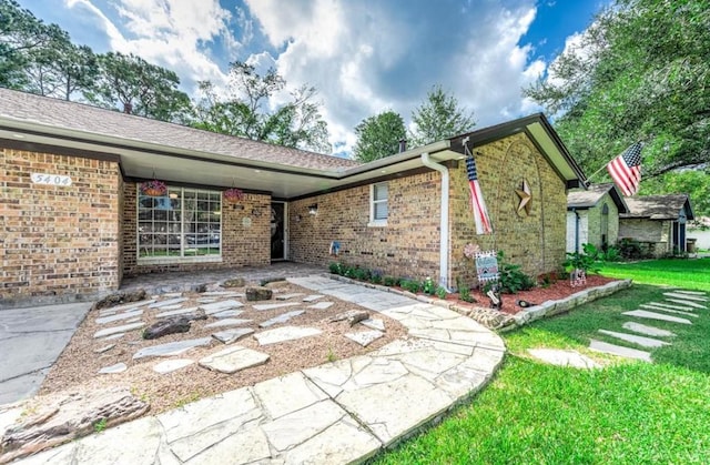 view of front of home featuring a front yard and a patio area