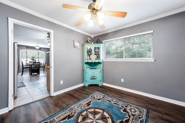 interior space featuring ceiling fan, ornamental molding, hardwood / wood-style floors, and a textured ceiling