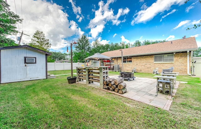 view of yard with a storage shed, a gazebo, a patio area, and a fire pit