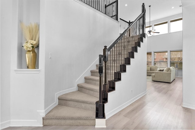 stairway with a high ceiling and wood-type flooring