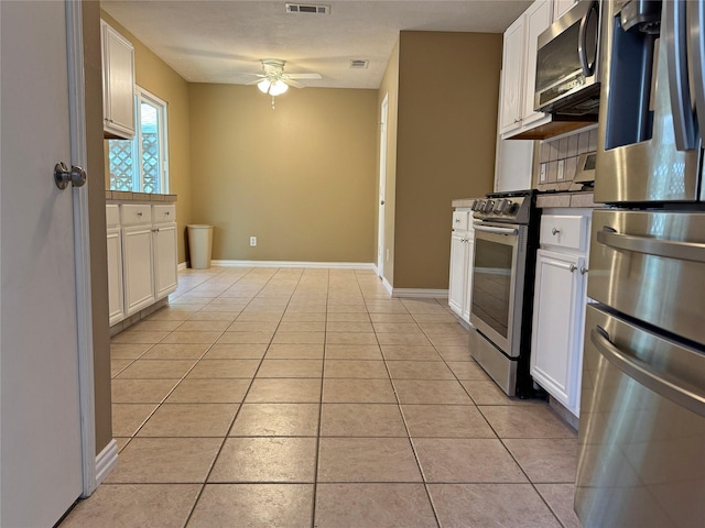 kitchen featuring white cabinetry, light tile patterned floors, ceiling fan, stainless steel appliances, and backsplash