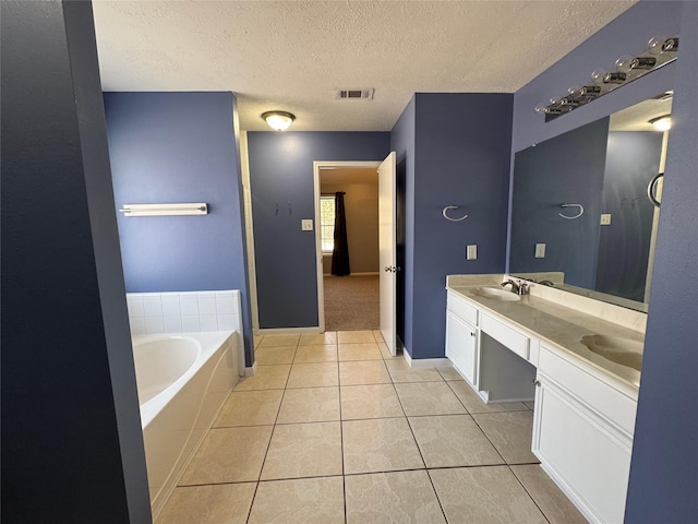 full bathroom with a textured ceiling, visible vents, a bath, tile patterned floors, and double vanity